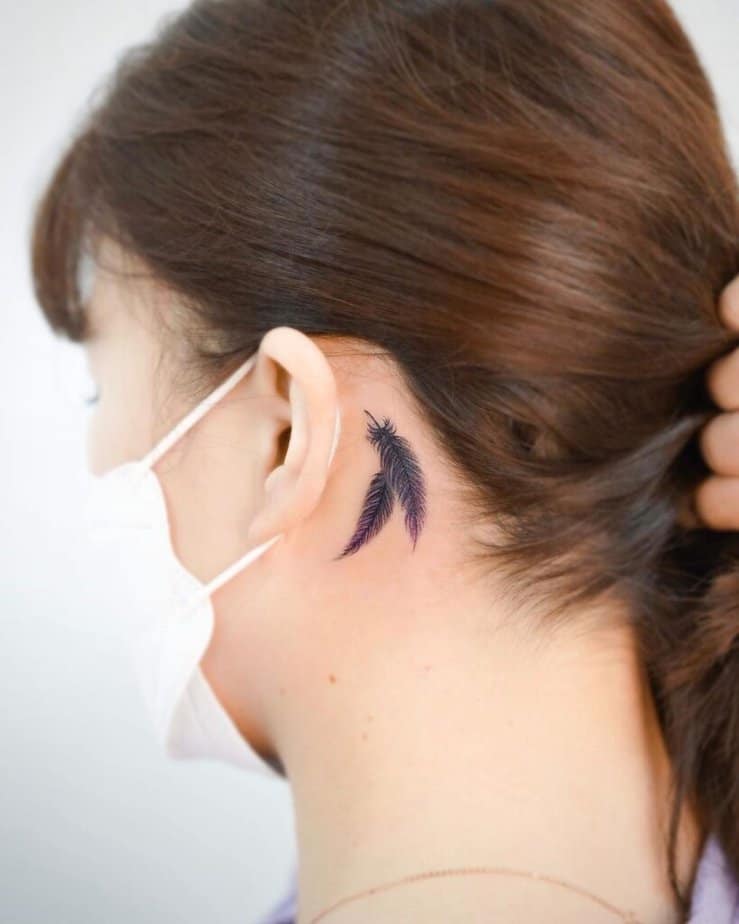 A feather tattoo behind the ear