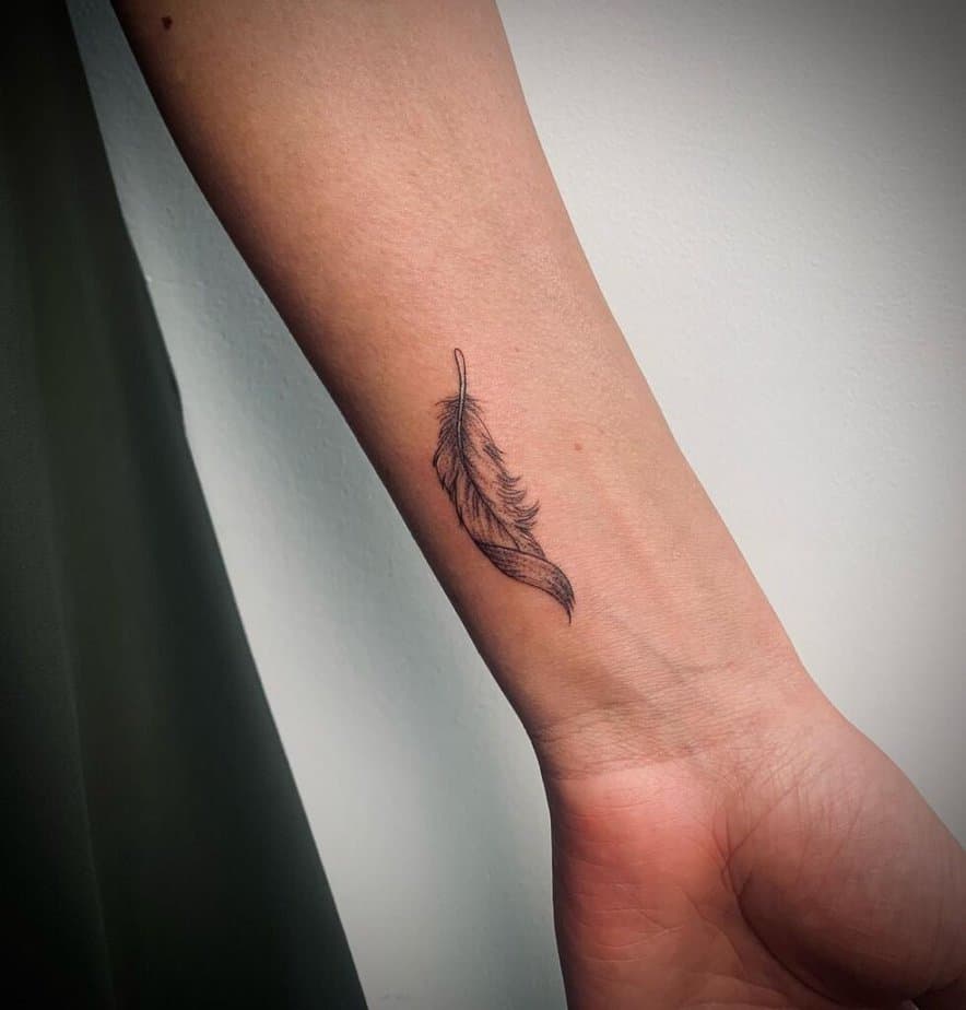 A fine-line feather tattoo