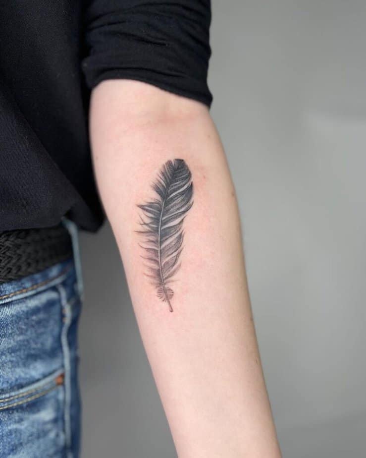 A simple and sleek feather tattoo on the forearm