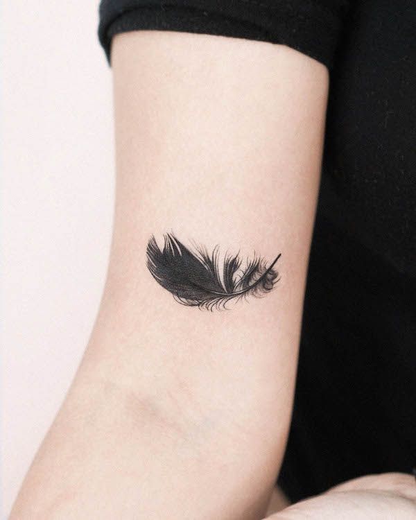 Intricate black feather tattoo