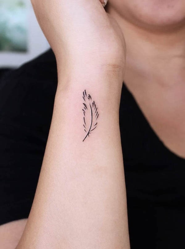 Minimalist feather wrist tattoo