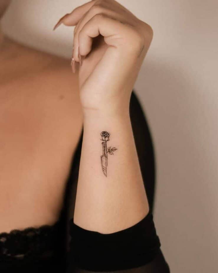 A tattoo of a rose and a knife