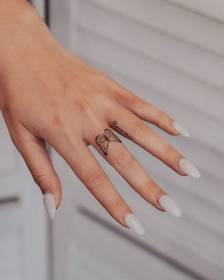 A butterfly finger tattoo with the word “love”