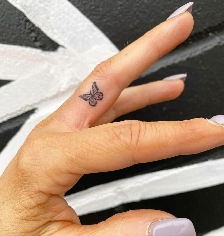 A dainty butterfly finger tattoo