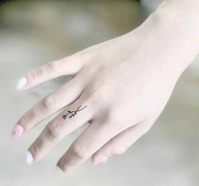 A dainty floral finger tattoo