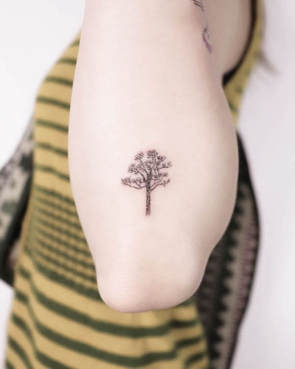 Tiny pine tree elbow tattoo